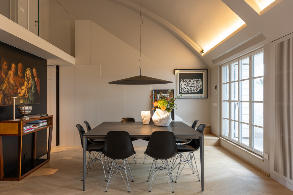 Idee per una sala da pranzo aperta verso la cucina design con pareti bianche, parquet chiaro e pavimento beige