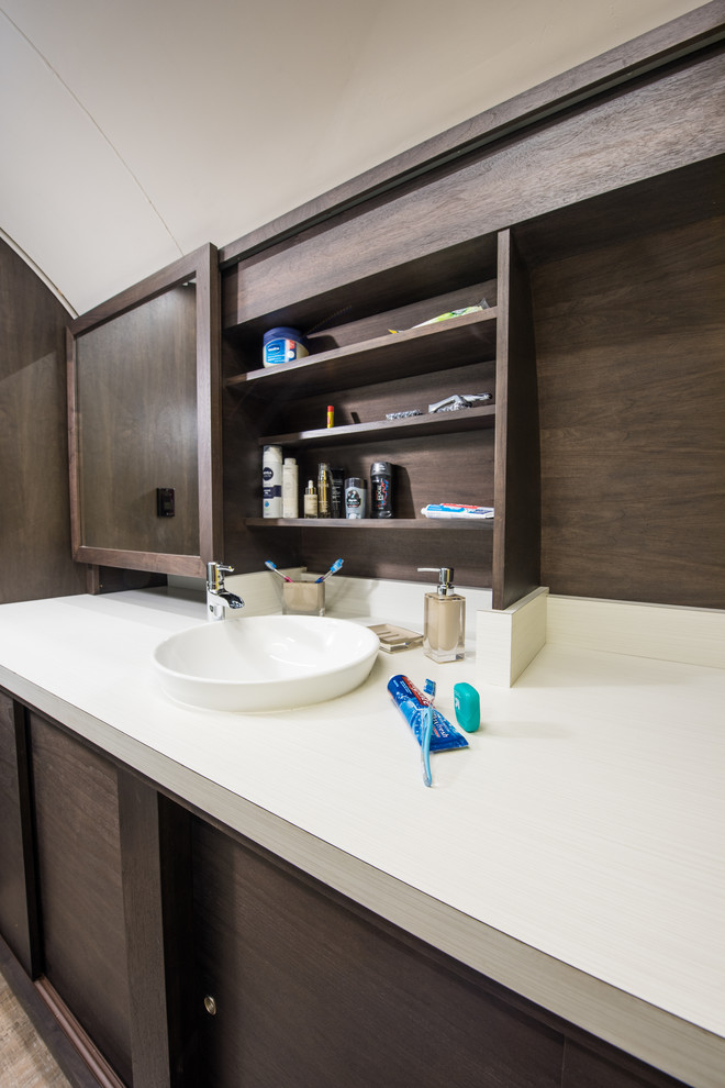 This is an example of a small modern master bathroom in Other with a vessel sink, flat-panel cabinets, dark wood cabinets, laminate benchtops, a one-piece toilet, white tile, glass tile, yellow walls and vinyl floors.