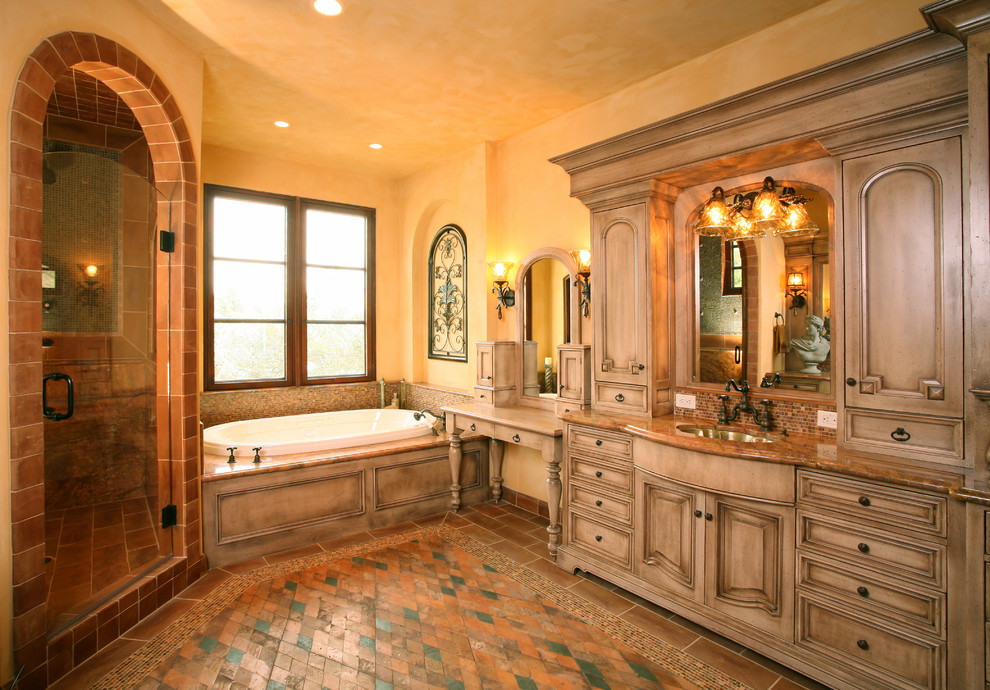 Mediterranean bathroom in Other with raised-panel cabinets, medium wood cabinets, a drop-in tub and a corner shower.