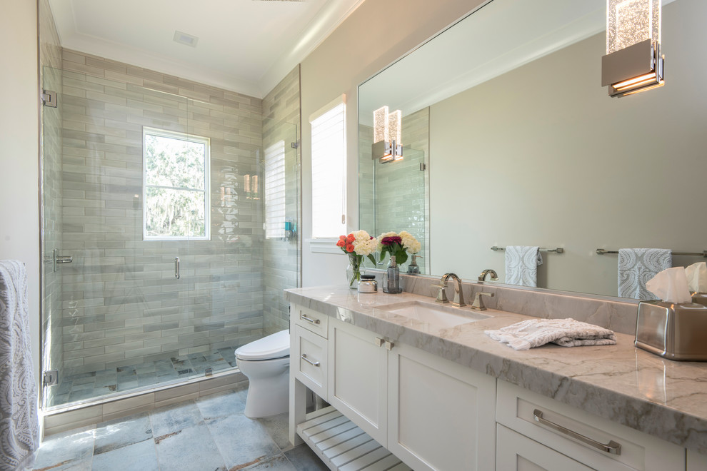 Transitional bathroom in Orlando with shaker cabinets, white cabinets, an alcove shower, gray tile, grey walls, an undermount sink, grey floor, a hinged shower door and grey benchtops.