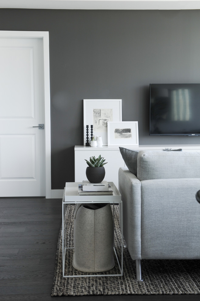 Photo of a small contemporary open concept living room in Vancouver with grey walls, medium hardwood floors and a wall-mounted tv.