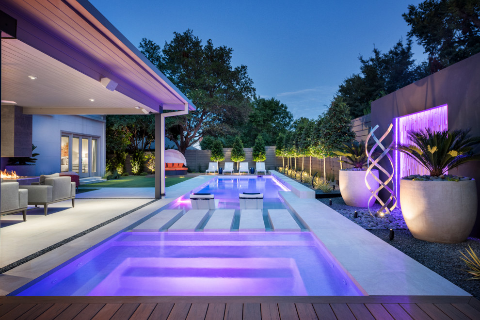 Inspiration for a large modern backyard rectangular pool in Dallas with with a pool and natural stone pavers.