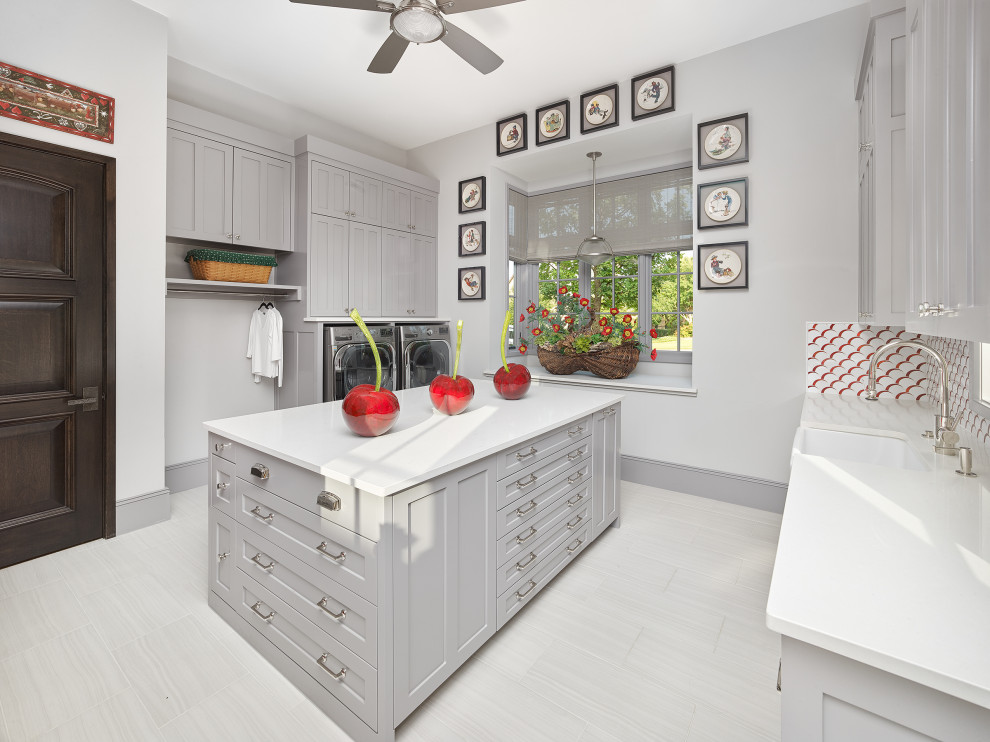 Design ideas for an expansive transitional utility room in Chicago with an undermount sink, recessed-panel cabinets, grey cabinets, grey walls, a side-by-side washer and dryer, white floor and white benchtop.