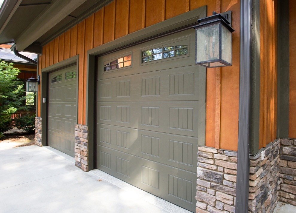 Photo of an expansive arts and crafts attached three-car garage in Other.