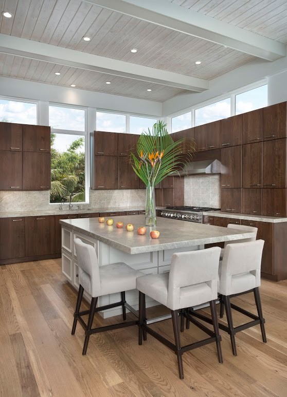 This is an example of a large contemporary l-shaped eat-in kitchen in Miami with flat-panel cabinets, dark wood cabinets, grey splashback, cement tile splashback, panelled appliances, medium hardwood floors, with island and brown floor.