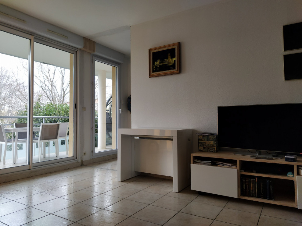 На фото: гостиная комната в белых тонах с отделкой деревом в современном стиле с отдельно стоящим телевизором