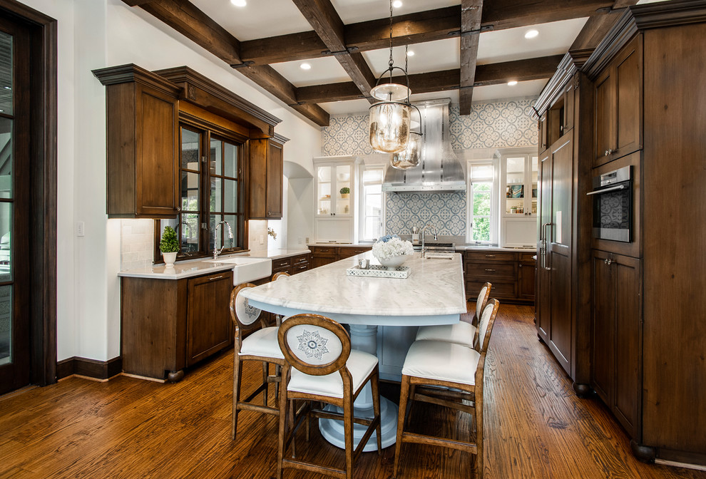 Inspiration for a large traditional kitchen in Dallas with a farmhouse sink, marble benchtops, multi-coloured splashback, medium hardwood floors, with island, shaker cabinets, dark wood cabinets, panelled appliances and white benchtop.