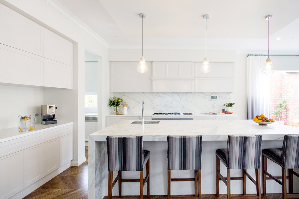 Large transitional l-shaped open plan kitchen in Melbourne with an undermount sink, marble benchtops, white splashback, marble splashback, dark hardwood floors, with island and brown floor.
