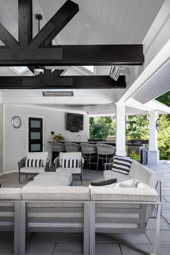 Example of a huge trendy backyard brick patio kitchen design in Newark with a roof extension
