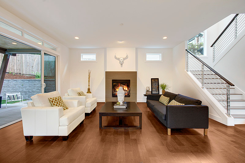 Design ideas for a contemporary open concept family room in Seattle with white walls, medium hardwood floors, a standard fireplace and a tile fireplace surround.