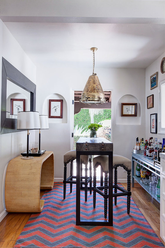 Inspiration for a small mediterranean seated home bar in Los Angeles with medium hardwood floors and no sink.