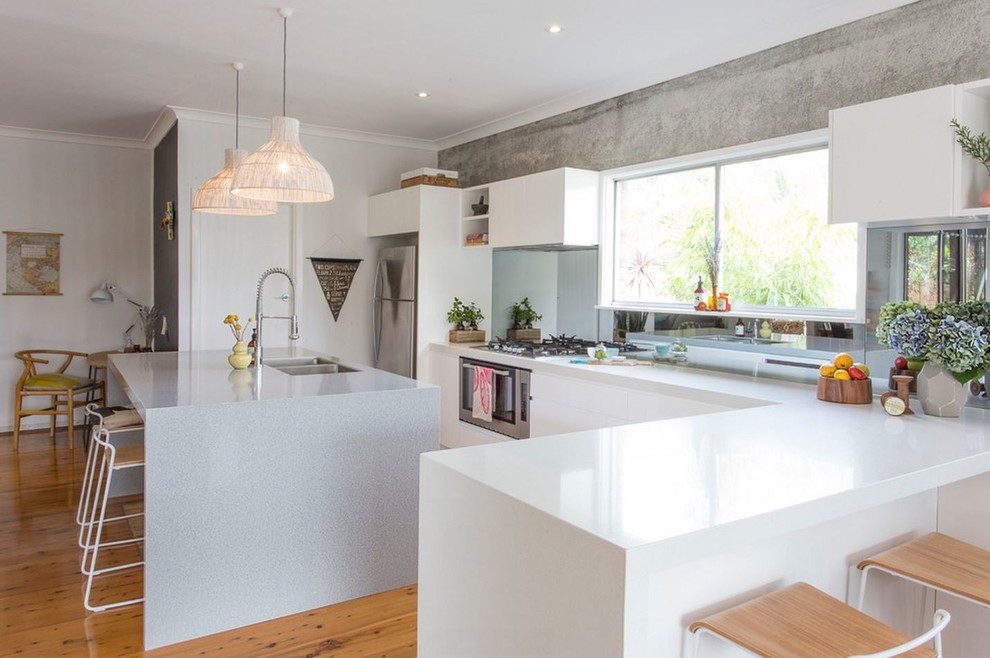 Design ideas for a large scandinavian l-shaped eat-in kitchen in Other with a double-bowl sink, flat-panel cabinets, white cabinets, quartz benchtops, white splashback, glass tile splashback, stainless steel appliances, light hardwood floors and with island.