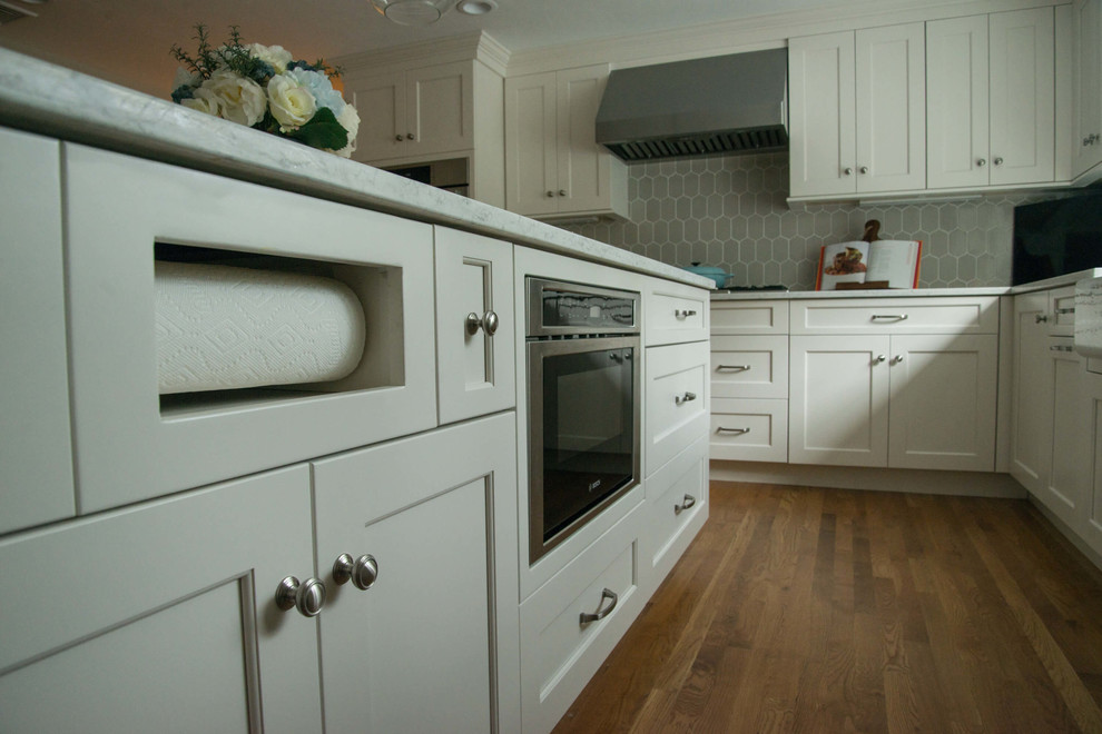 Home design - transitional l-shaped home design idea in Providence with a farmhouse sink, quartzite countertops, ceramic backsplash, stainless steel appliances and an island