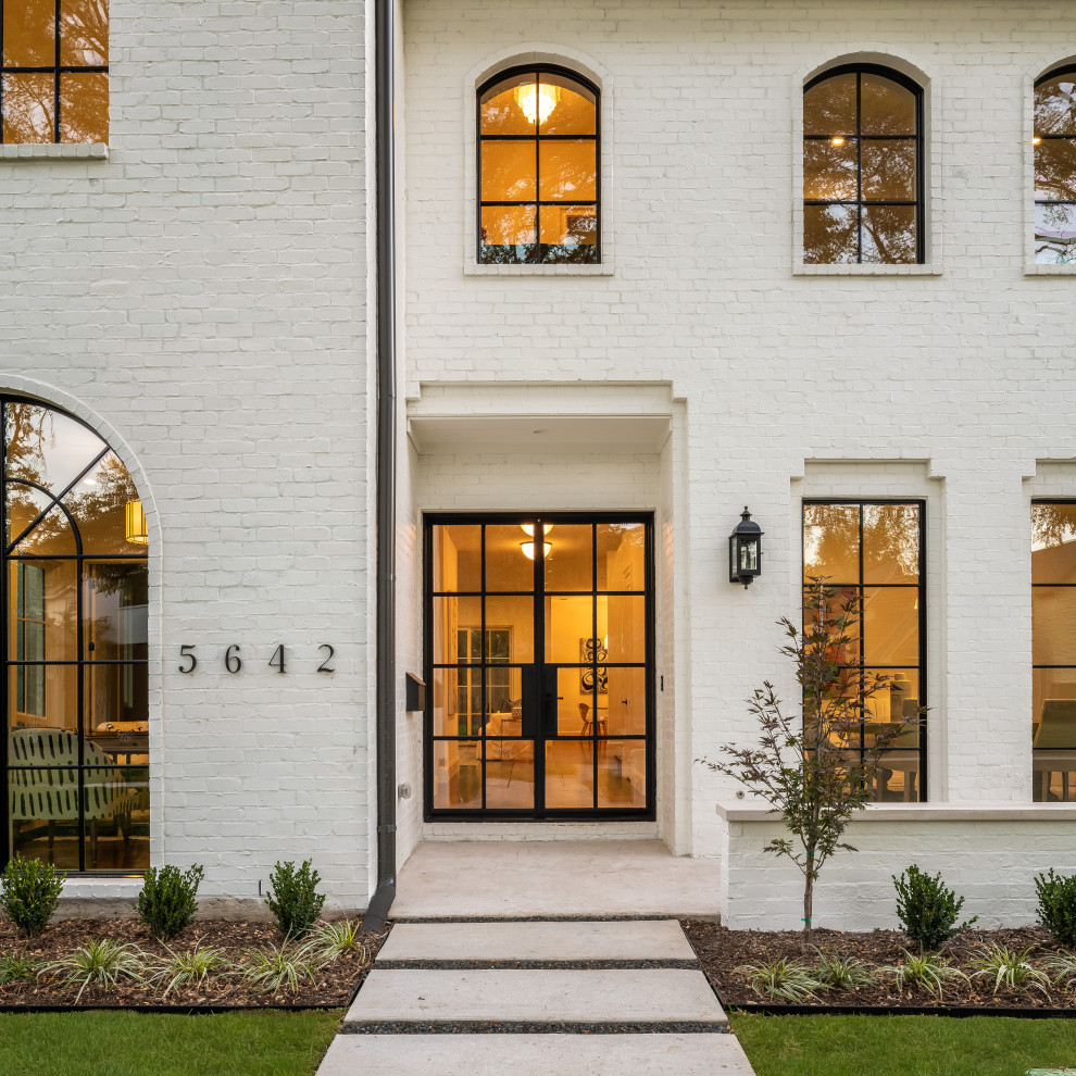 Large transitional two-storey white house exterior in Dallas with painted brick siding and a shingle roof.