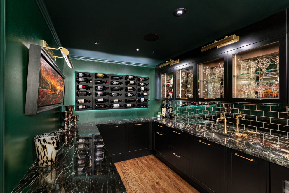Example of a large eclectic u-shaped dark wood floor and beige floor wet bar design in Detroit with an undermount sink, glass-front cabinets, black cabinets, quartzite countertops, gray backsplash, mirror backsplash and black countertops