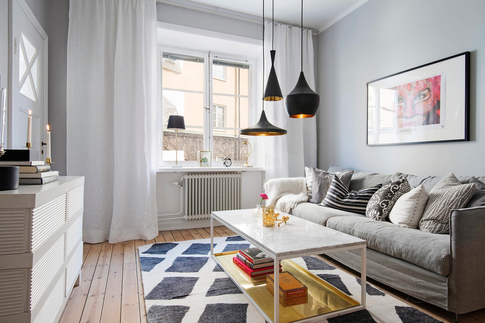 Foto på ett mellanstort nordiskt allrum med öppen planlösning, med grå väggar, ljust trägolv och ett finrum