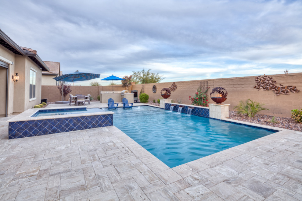 Diseño de piscina natural contemporánea grande rectangular en patio trasero con paisajismo de piscina y adoquines de hormigón