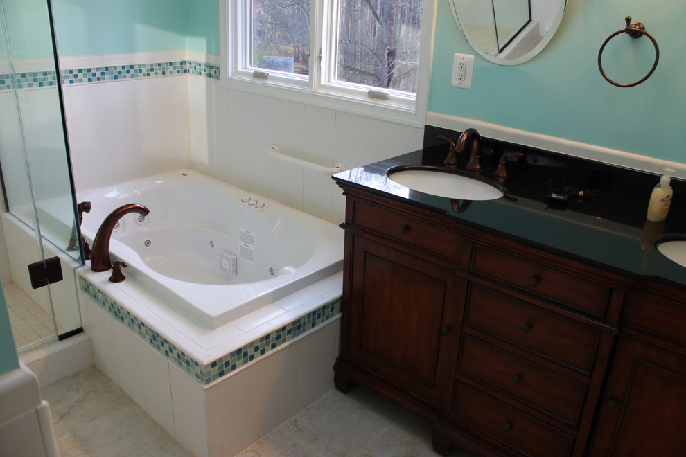 Example of a large transitional white tile and ceramic tile ceramic tile drop-in bathtub design in DC Metro with an undermount sink, raised-panel cabinets, dark wood cabinets, granite countertops, a two-piece toilet and blue walls
