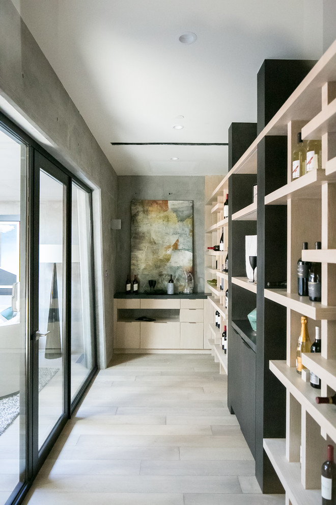 Design ideas for a contemporary wine cellar in Orange County with light hardwood floors and beige floor.