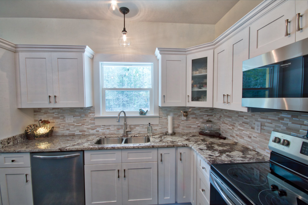 Inspiration for a mid-sized l-shaped eat-in kitchen remodel with an undermount sink, shaker cabinets, yellow cabinets, granite countertops, glass tile backsplash, stainless steel appliances, an island and white countertops