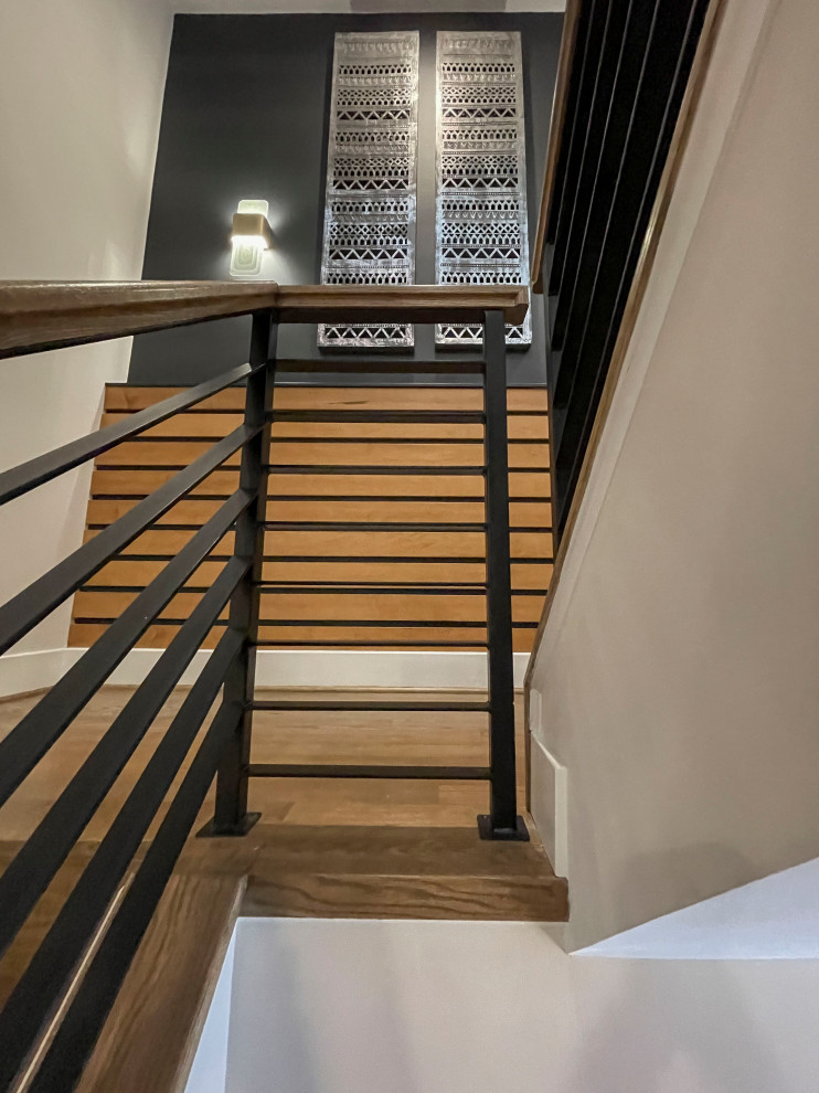 Diseño de escalera recta actual grande con escalones de madera, barandilla de varios materiales y panelado