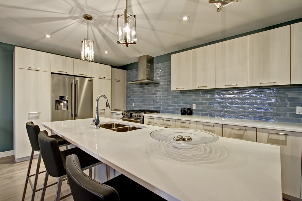 Example of a mid-sized transitional l-shaped light wood floor eat-in kitchen design in Toronto with a double-bowl sink, flat-panel cabinets, light wood cabinets, quartz countertops, green backsplash, glass tile backsplash, stainless steel appliances and an island