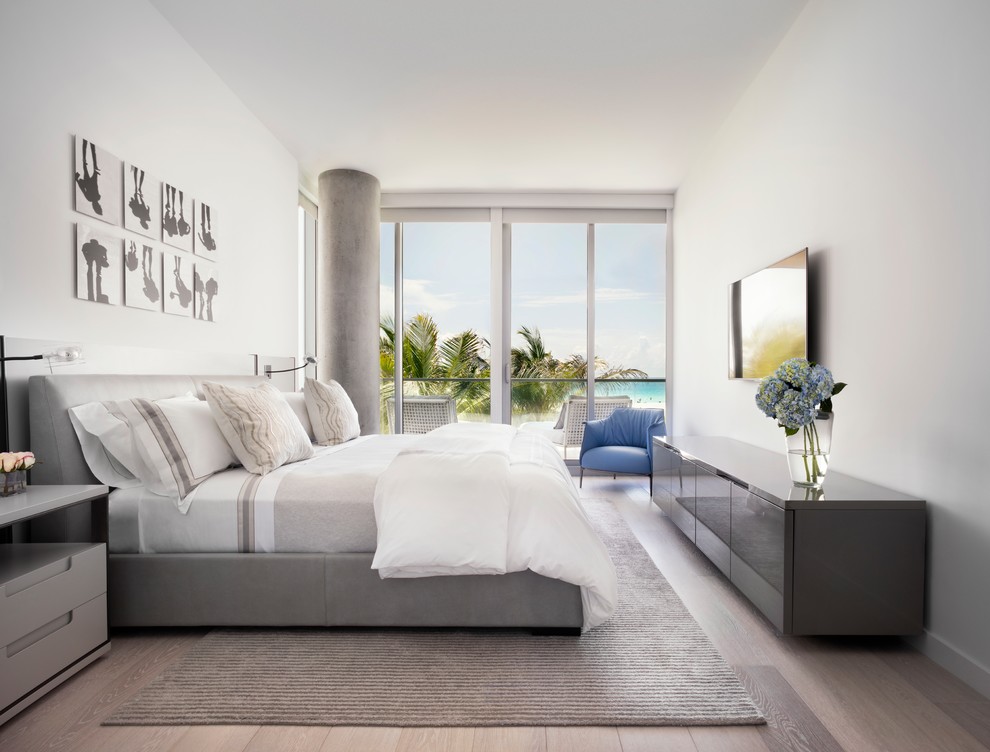Inspiration for a large contemporary master light wood floor and brown floor bedroom remodel in Miami with white walls and no fireplace