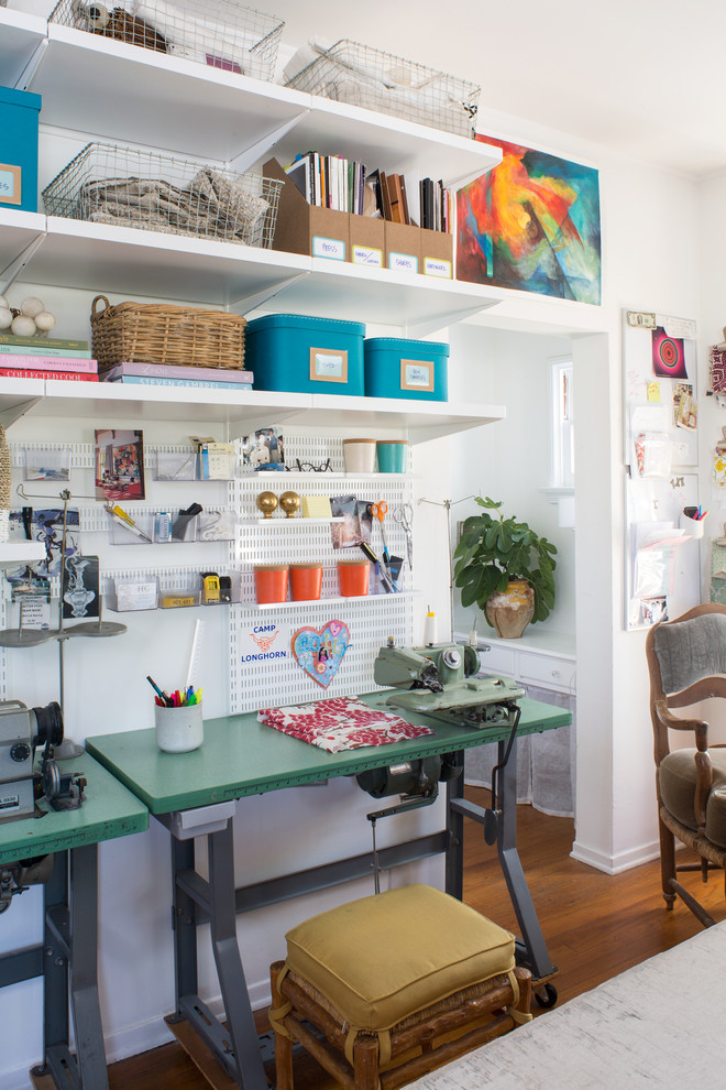 Transitional freestanding desk medium tone wood floor craft room photo with white walls