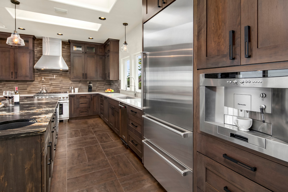 Enclosed kitchen - mid-sized transitional l-shaped porcelain tile enclosed kitchen idea in Phoenix with an undermount sink, shaker cabinets, dark wood cabinets, quartz countertops, beige backsplash, stone tile backsplash, stainless steel appliances and an island