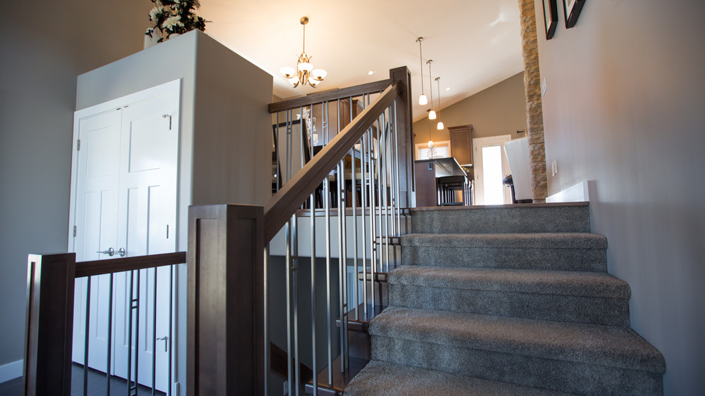 This is an example of a large arts and crafts carpeted staircase in Other with concrete risers and mixed railing.