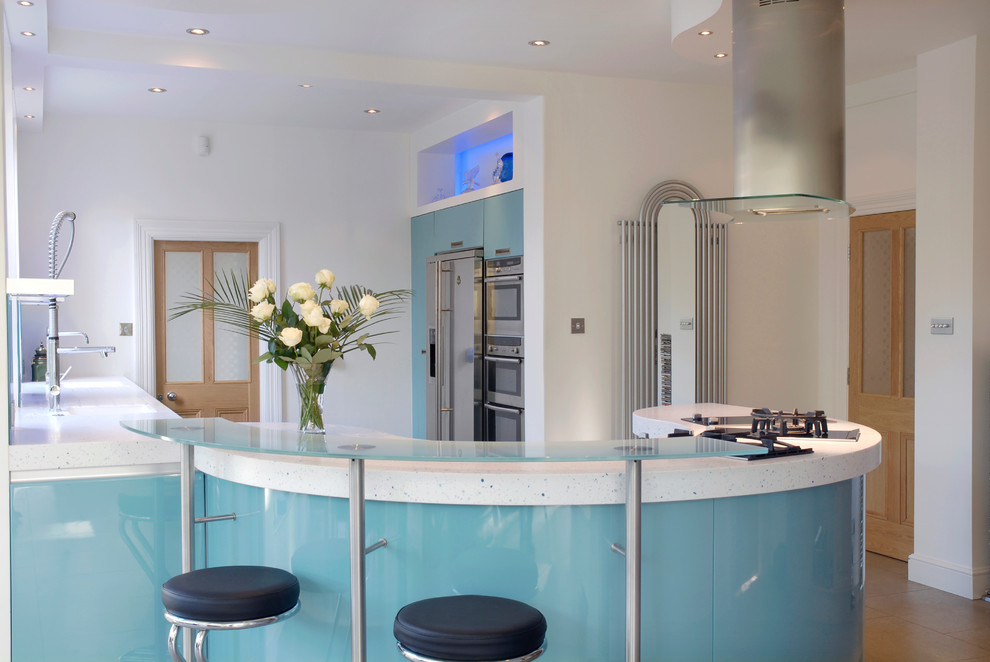 Large modern u-shaped eat-in kitchen in London with an integrated sink, flat-panel cabinets, blue cabinets, solid surface benchtops, blue splashback, glass sheet splashback, stainless steel appliances, ceramic floors and a peninsula.