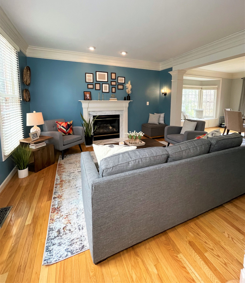 Exemple d'un salon chic de taille moyenne et ouvert avec un mur bleu, un sol en bois brun et une cheminée standard.