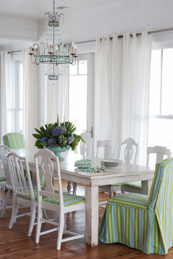 Photo of a beach style dining room in Atlanta with white walls and medium hardwood floors.
