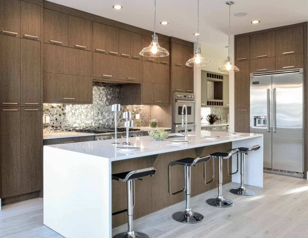 Design ideas for a large contemporary galley eat-in kitchen in Calgary with an undermount sink, flat-panel cabinets, dark wood cabinets, quartz benchtops, metallic splashback, glass tile splashback, stainless steel appliances, light hardwood floors, with island, beige floor and white benchtop.