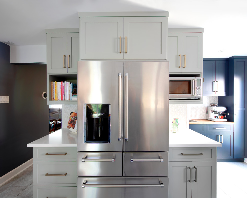 Kitchen - mid-sized transitional l-shaped ceramic tile kitchen idea in Ottawa with a double-bowl sink, shaker cabinets, quartz countertops, white backsplash, stainless steel appliances, a peninsula and white countertops