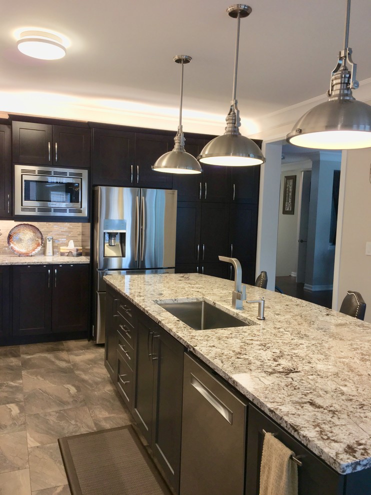 Inspiration for a large contemporary l-shaped separate kitchen in Toronto with an undermount sink, shaker cabinets, dark wood cabinets, granite benchtops, brown splashback, porcelain splashback, stainless steel appliances, porcelain floors, with island, brown floor and white benchtop.