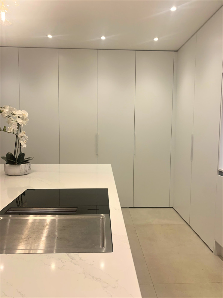 This is an example of a medium sized contemporary l-shaped kitchen in Other with a single-bowl sink, flat-panel cabinets, dark wood cabinets, quartz worktops, white splashback, glass sheet splashback, stainless steel appliances, porcelain flooring, an island, grey floors and white worktops.