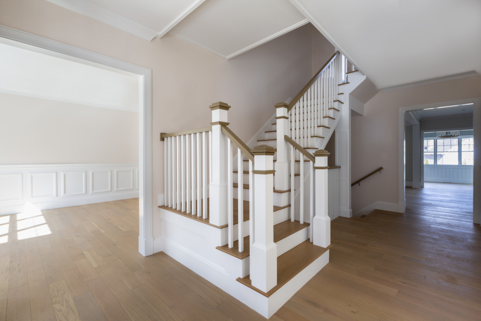 Example of a mid-sized transitional light wood floor, beige floor and wall paneling foyer design in Boston with beige walls and a black front door