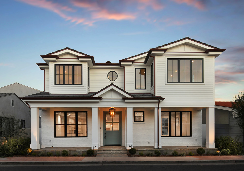 Example of a transitional white two-story exterior home design in Orange County with a shingle roof