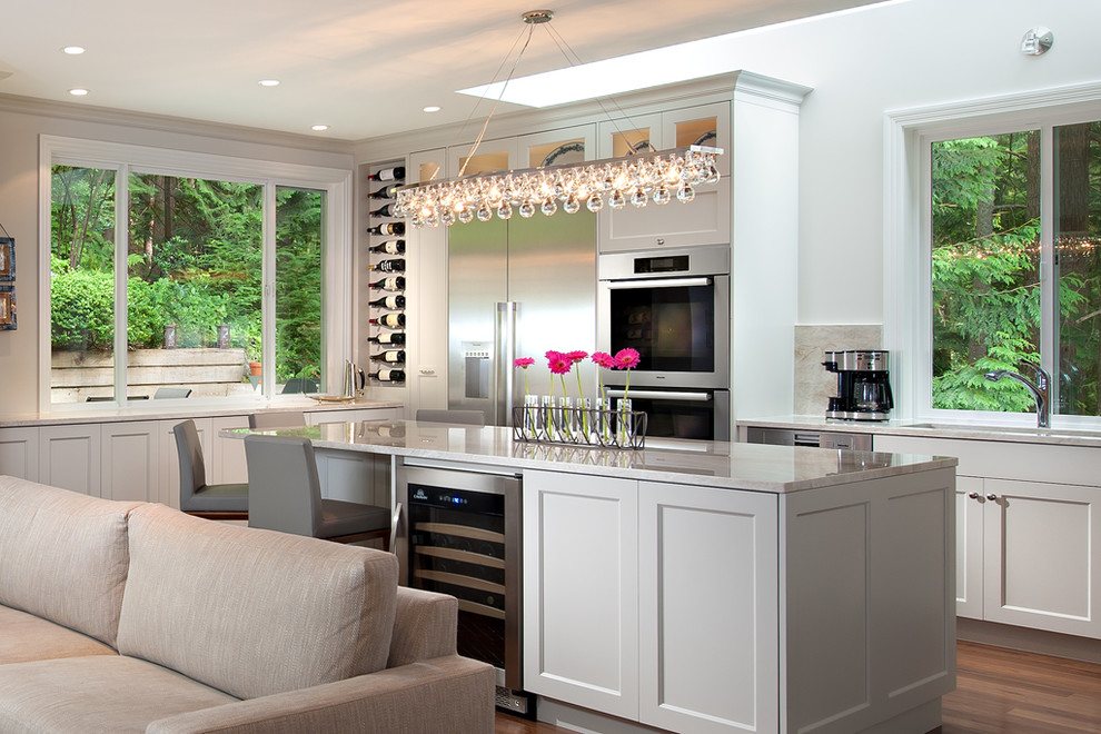 Example of a mid-sized transitional l-shaped dark wood floor and brown floor eat-in kitchen design in Vancouver with recessed-panel cabinets, gray cabinets, marble countertops, multicolored backsplash, stainless steel appliances, an island and gray countertops