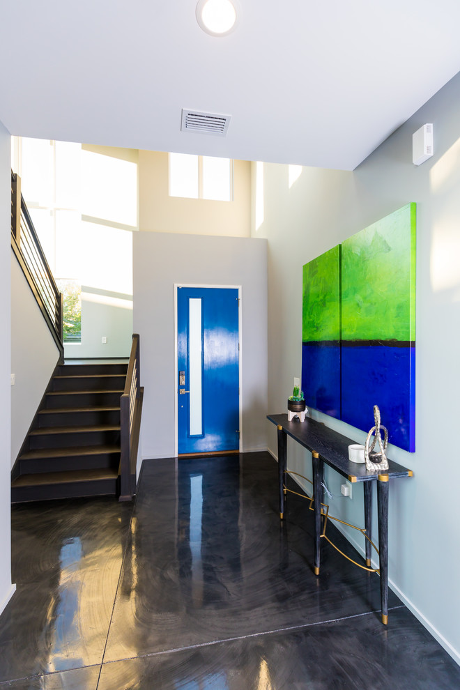 This is an example of a mid-sized modern foyer in Jacksonville with grey walls, concrete floors, a single front door, a blue front door and grey floor.