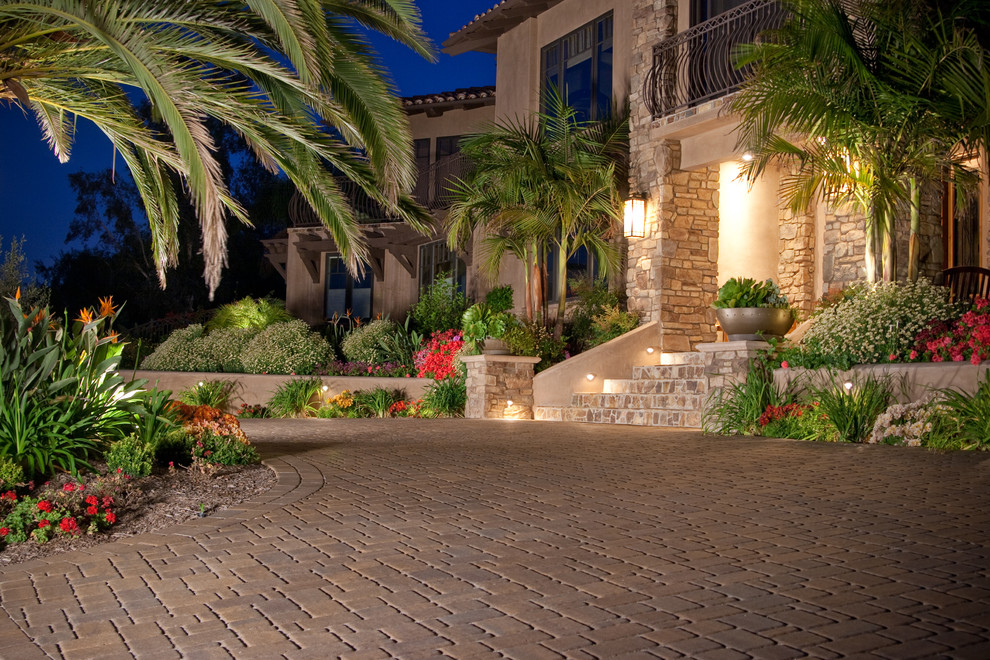 Expansive mediterranean front yard driveway in San Diego with concrete pavers.