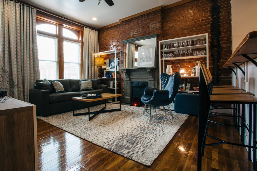 Photo of a mid-sized transitional open concept living room in St Louis with a home bar, medium hardwood floors, a standard fireplace, a wood fireplace surround and brown floor.