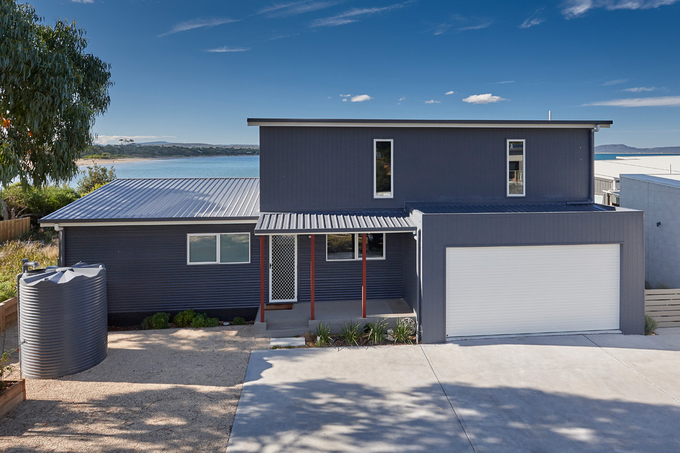 Contemporary two-storey grey house exterior in Other with a shed roof and a metal roof.