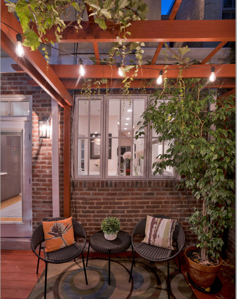 Cette image montre une terrasse arrière et au premier étage vintage de taille moyenne avec des solutions pour vis-à-vis, une pergola et un garde-corps en bois.