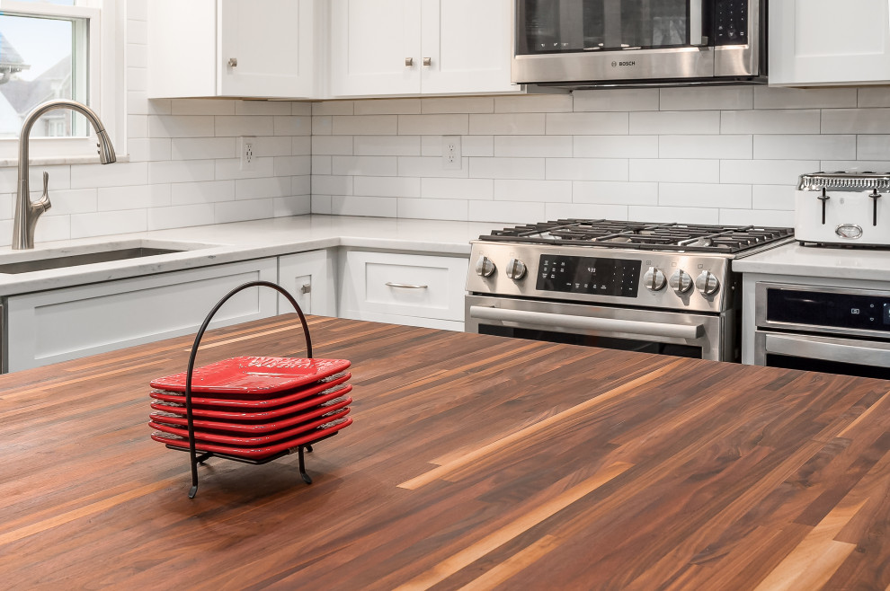 Inspiration for a mid-sized transitional l-shaped eat-in kitchen remodel in Columbus with shaker cabinets, quartz countertops, white backsplash, subway tile backsplash and an island