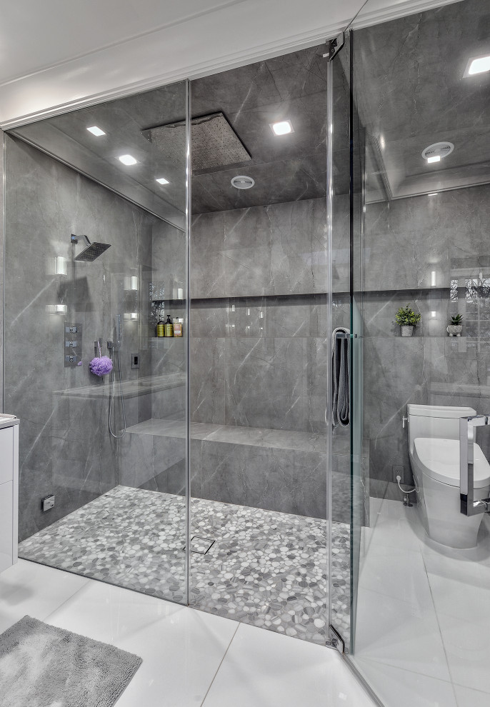 Design ideas for a large modern master bathroom in New York with flat-panel cabinets, white cabinets, a curbless shower, a bidet, gray tile, porcelain tile, grey walls, marble floors, an integrated sink, marble benchtops, white floor, a hinged shower door, grey benchtops, a shower seat, a double vanity, a floating vanity and coffered.