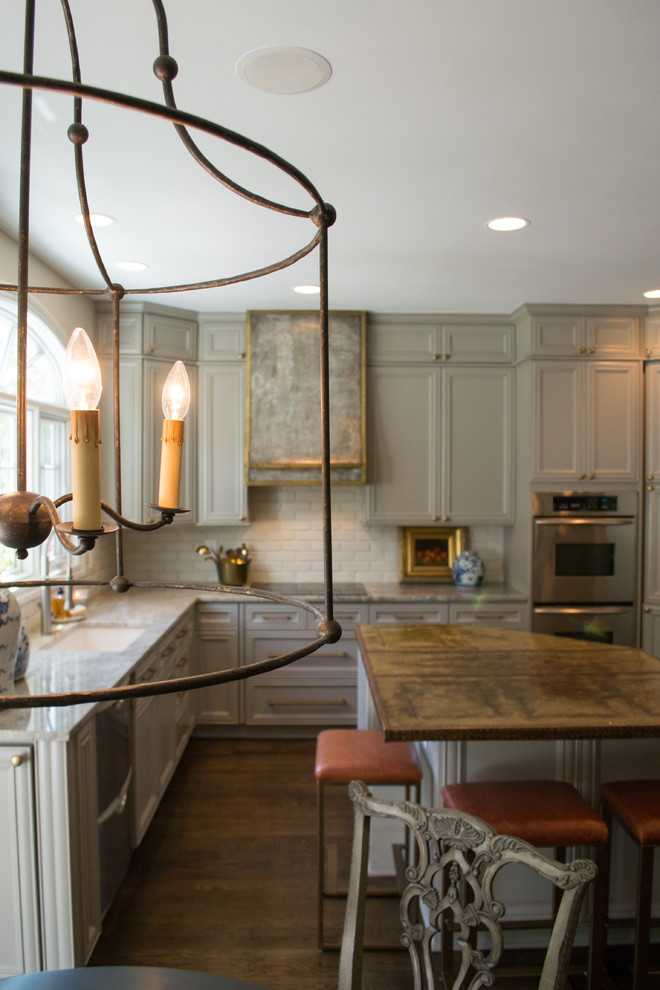 Inspiration for a mid-sized transitional dark wood floor and brown floor kitchen remodel in Columbus with white backsplash, stainless steel appliances and an island