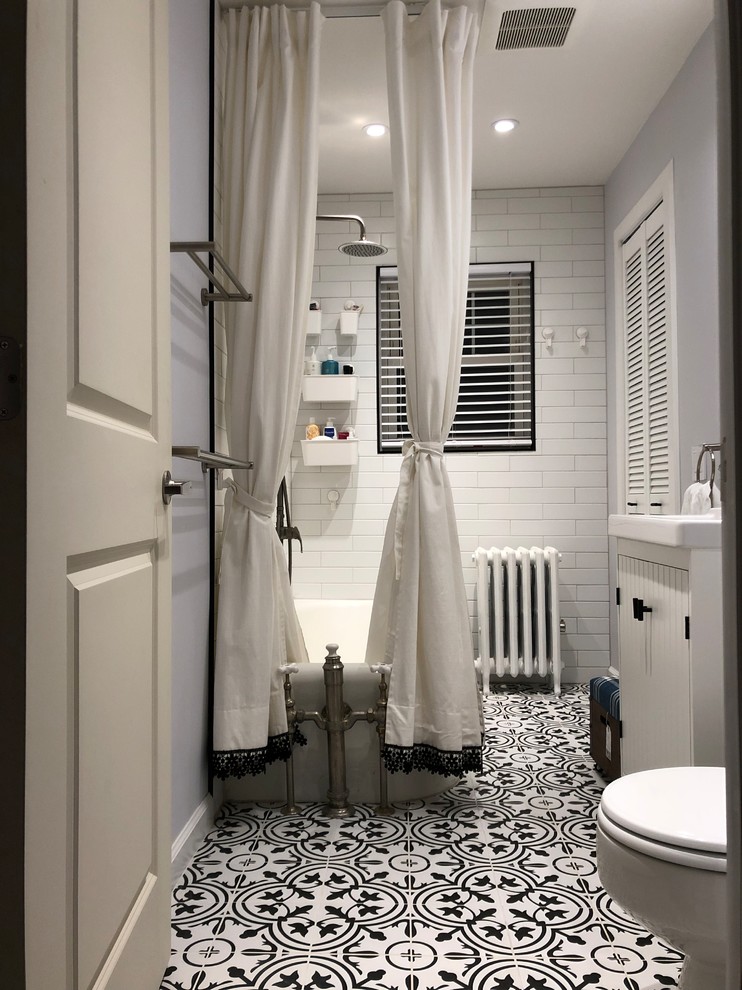 Inspiration for a small transitional master bathroom in New York with furniture-like cabinets, white cabinets, a corner tub, a one-piece toilet, white tile, ceramic tile, grey walls, ceramic floors, a drop-in sink, black floor, a shower curtain and white benchtops.
