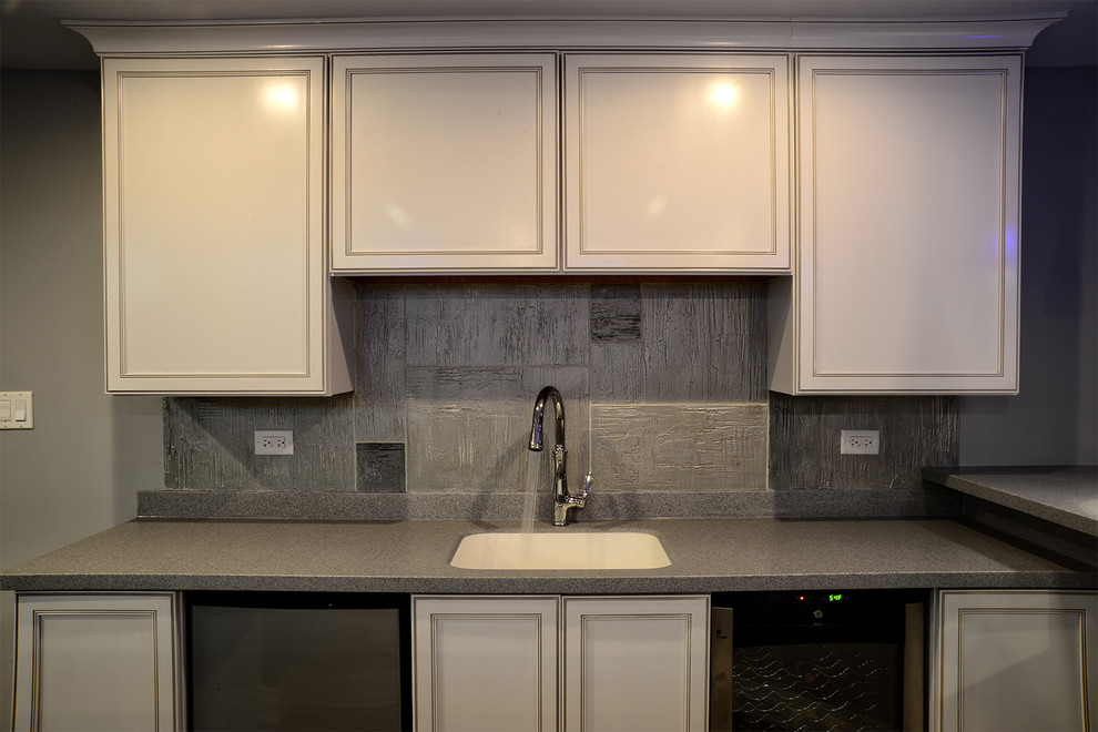 Elegant single-wall eat-in kitchen photo in Phoenix with an undermount sink, recessed-panel cabinets, white cabinets, quartz countertops, metallic backsplash, stainless steel appliances and an island